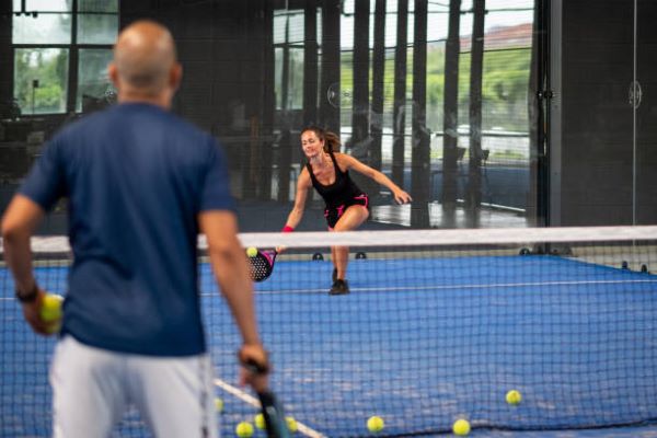 Pádel México; mujer entrenando padel con un señor mayor 